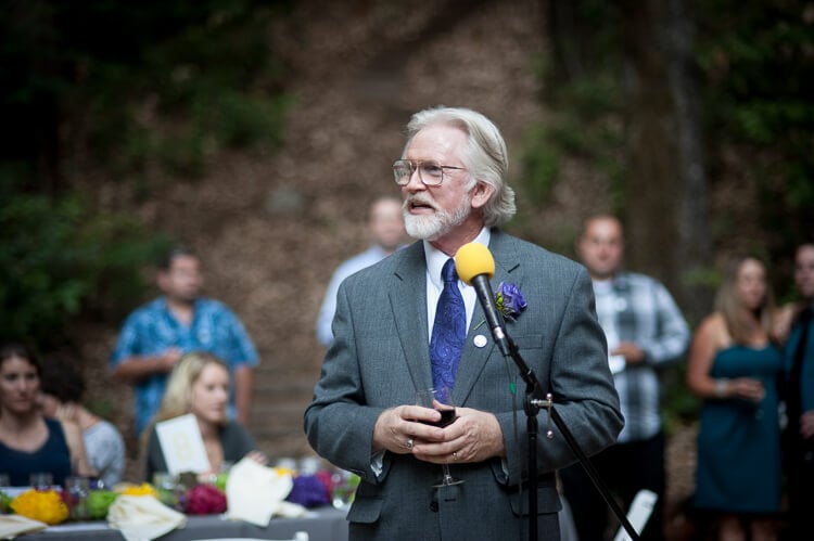 An older gentleman standing next to a microphone