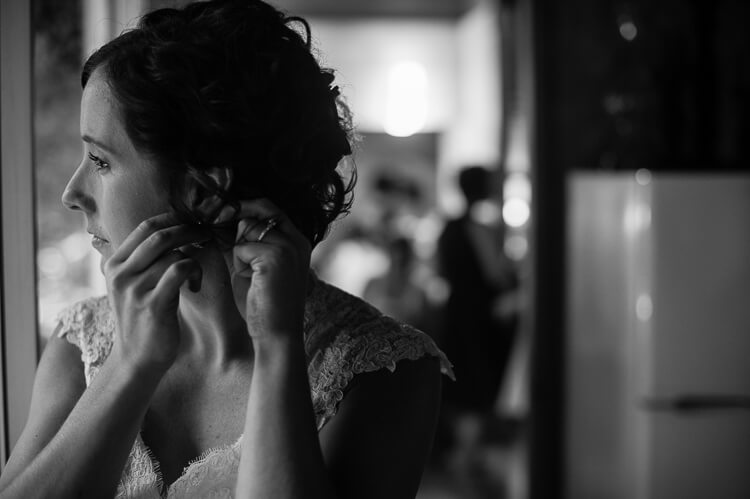 A bride putting on earrings