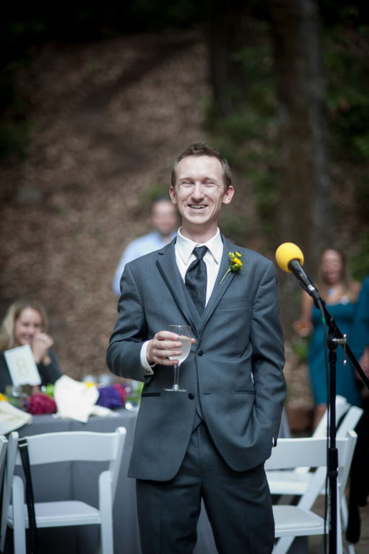 A groomsman standing next to a microphone