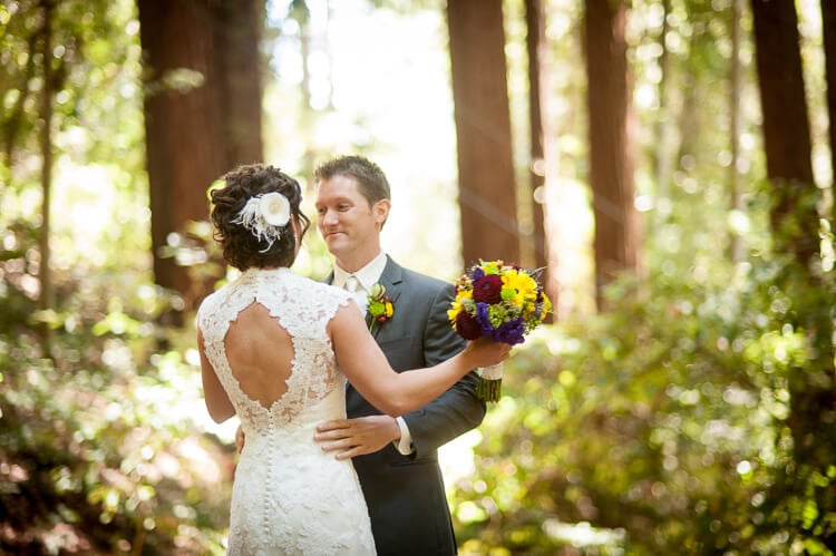 A bride and a groom standing among trees