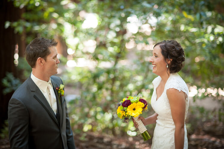 A bride and a groom standing among trees