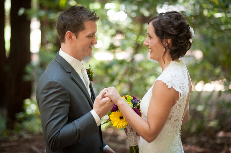 A bride and a groom standing among trees