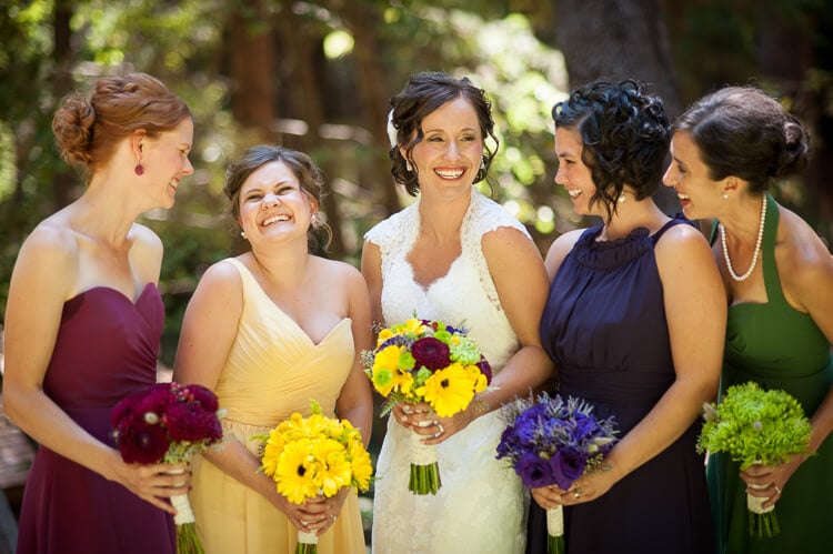 A bride and her bridesmaids looking at each other and smiling
