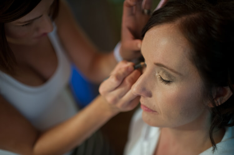 A woman getting her makeup done by another woman