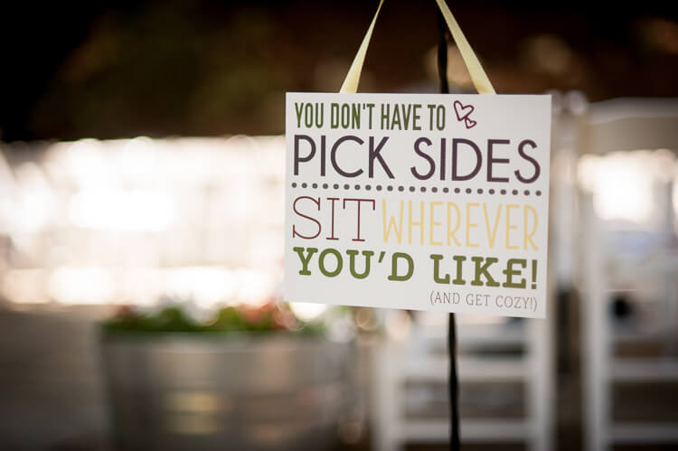 A sign that says, \"You Don\'t Have to Pick Sides, Sit Wherever You\'d Like! (and get cozy)\"