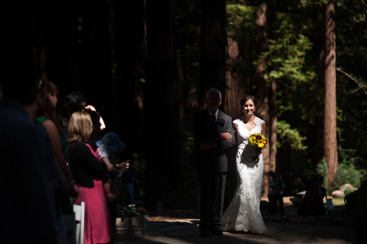 A bride walking up the aisle by her father