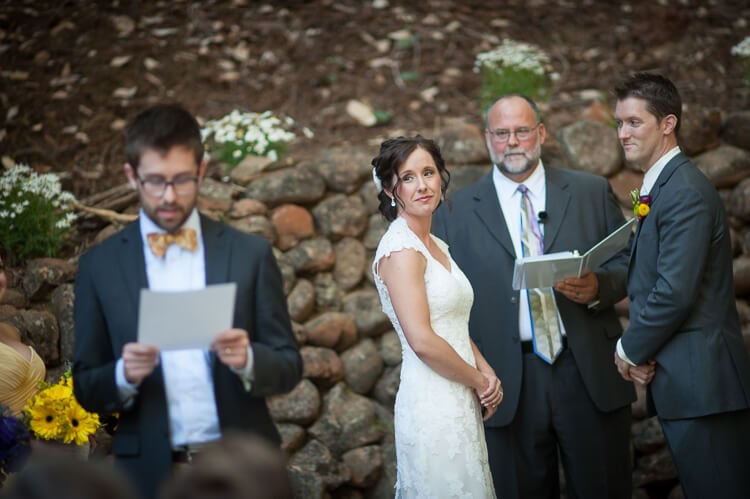A bride and minister looking a person reading from a piece of paper