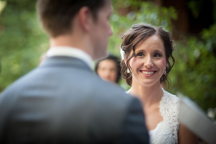 A bride smiling and looking at her groom