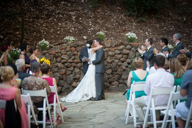 A bride and groom kissing and people clapping