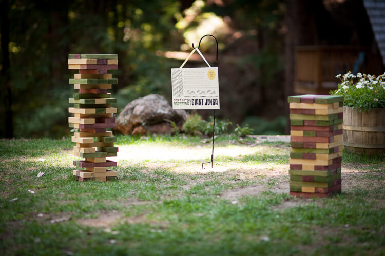 A sign that says, \"Giant Junga\" and the game pieces sitting on the grass