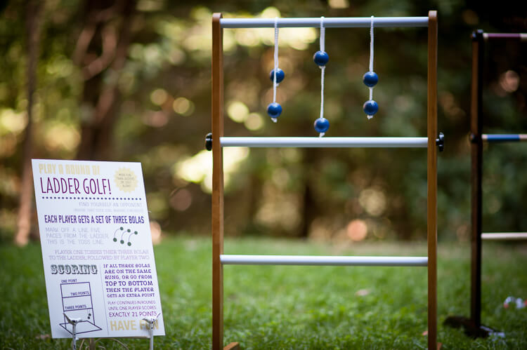 A sign that says, \"Ladder Golf\" and the game sitting on the grass