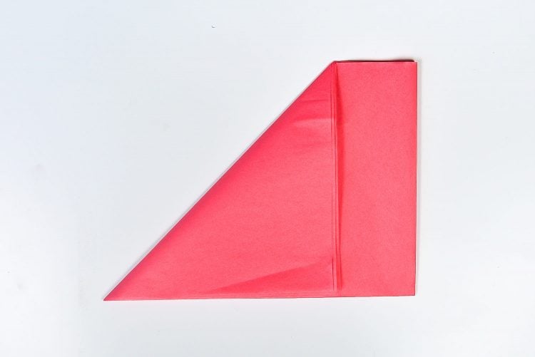 A pink piece of tissue paper folded into a triangle shape