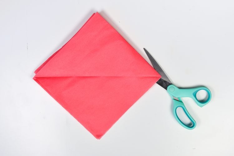 How to Make Tissue Paper Flowers: Cut folded edge to separate all 8 pieces of tissue paper.