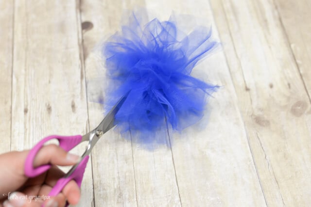 scissors separating blue tulle to make poofy firework look