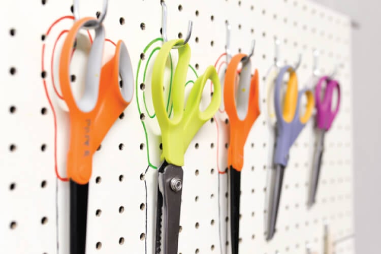 scissors organized on peg board with outlines