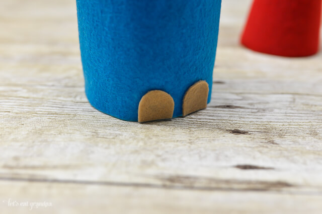 tan felt pieces on bottom of blue felt to make christmas gnome's feet