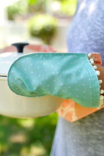 A person holding a pot with a potholder