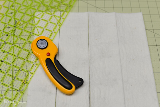 rotary cutter and strips of white felt