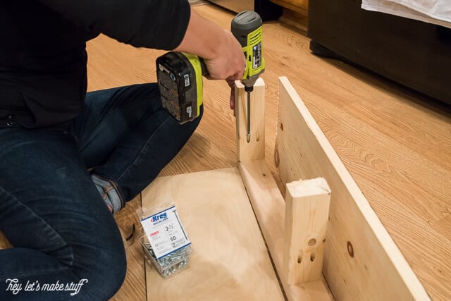 man drilling holes in wooden pieces