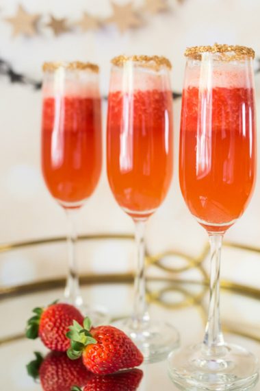 A table with champagne glasses and strawberries on a tray