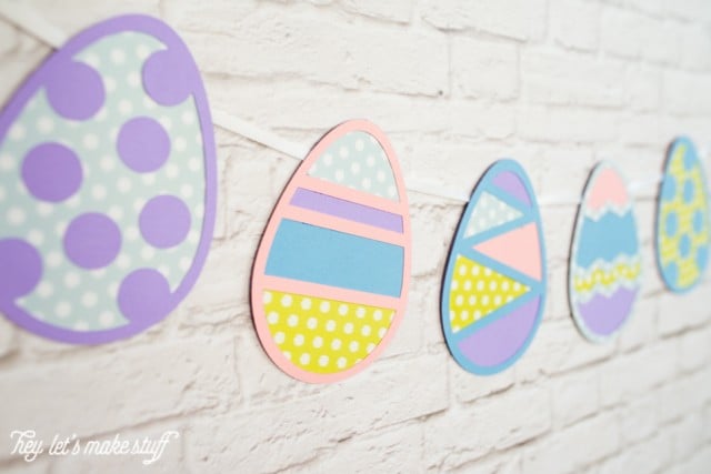 Easter Egg banner cut from paper hanging on a white brick wall