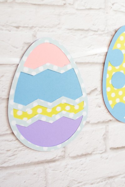 Close up of Easter Eggs cut from paper hanging on a white brick wall
