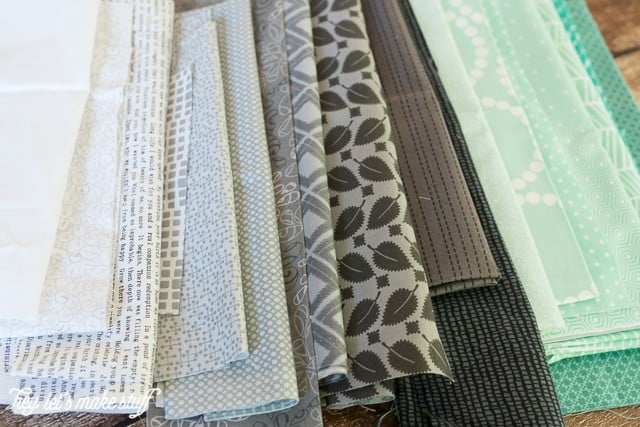 piles of various teal and gray fabric