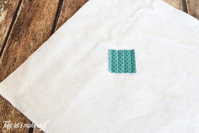 small teal fabric square on backing fabric