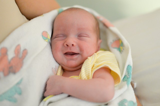 A picture of a little baby smiling in his sleep