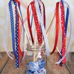 Patriotic streamers sticking out of a Mason jar that is sitting on a table