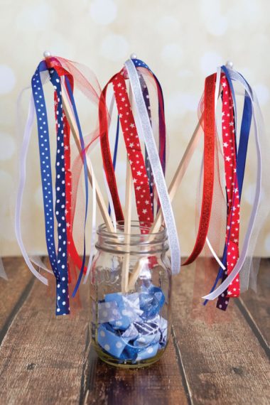 Patriotic streamers sticking out of a Mason jar that is sitting on a table