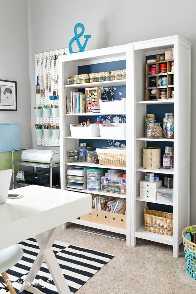 craft room bookshelves organized with various craft supplies