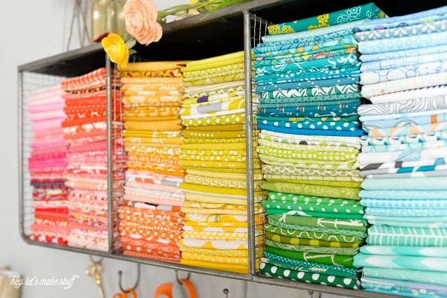 pretty colored fabric stacked in organizational wall hanging cubby