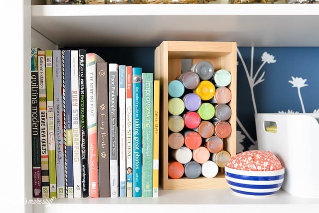 bookshelf with paint and books in craft room