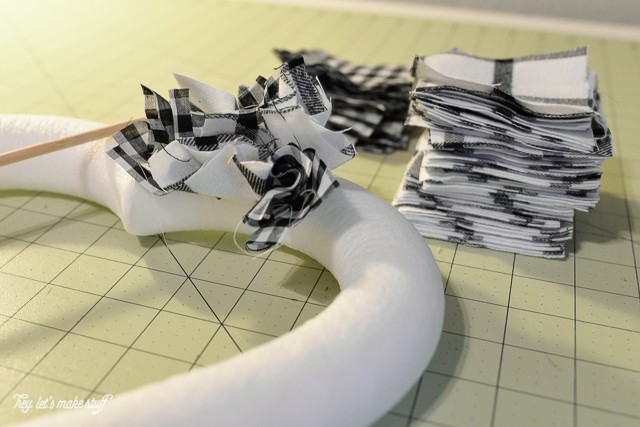 progress of black and white fabric squares on wooden dowel being glues to heart foam shape