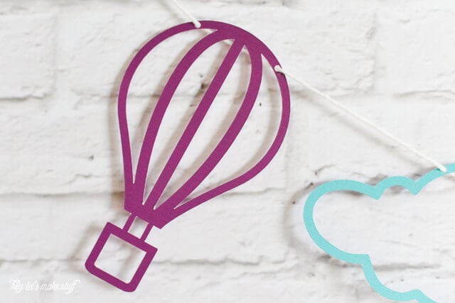 colorful hot air balloon and cloud SVG files cut on paper and strung against background