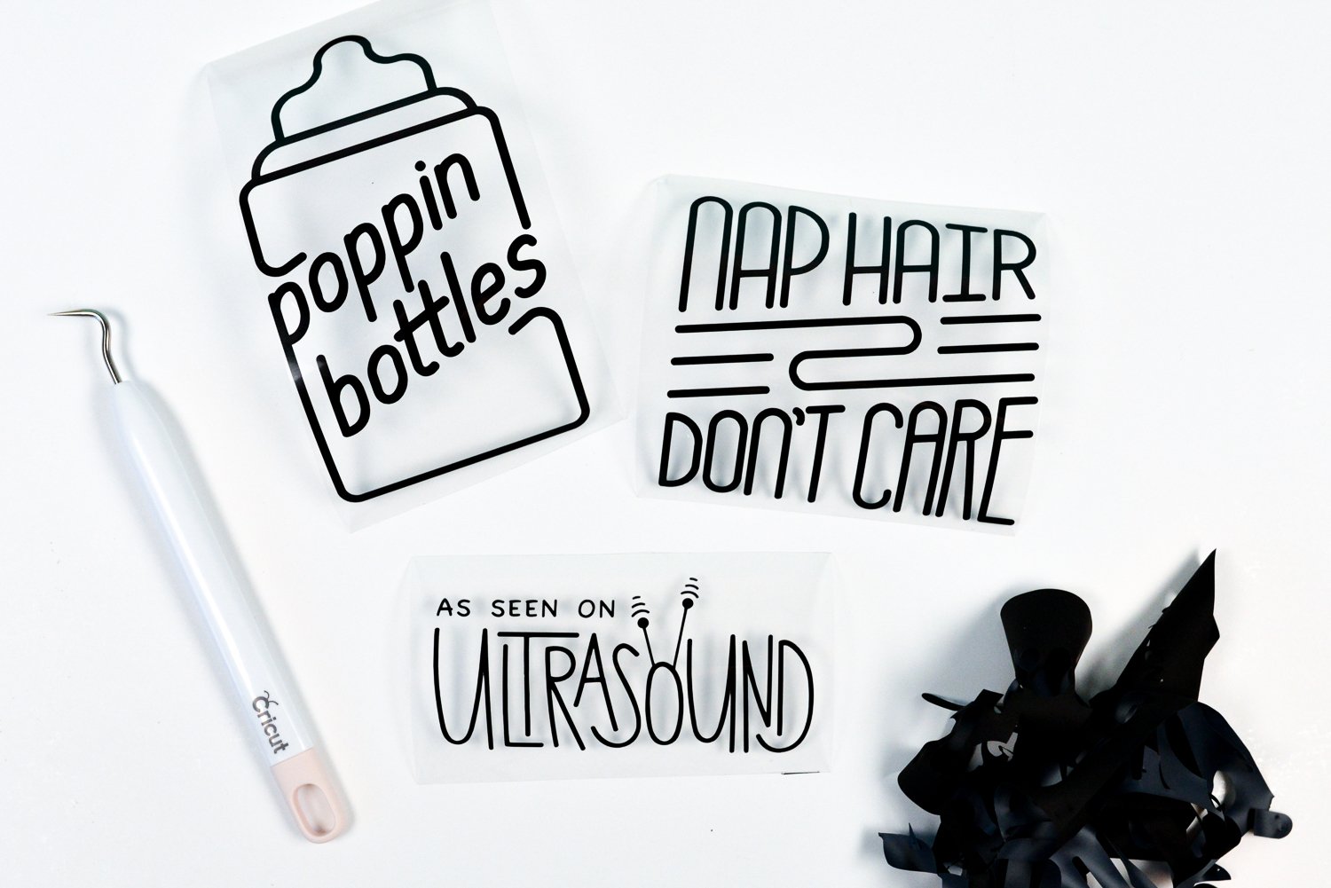 A Cricut weeding tool, a pile of weeded vinyl and three images that say, \" \"Poppin Bottles\", \"Nap Hair Don\'t Care\" and \"As Seen on Ultrasound\"