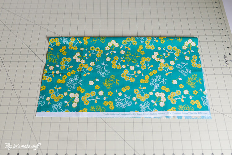 piece of fat quarter fabric folded in half on sewing mat
