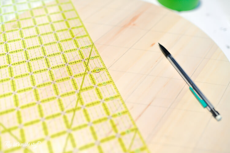 A round piece of wood, a ruler, a pencil and a roll of green tape