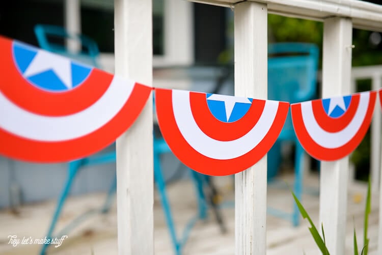 A close up of a patriotic bunting hanging from the front porch of a home