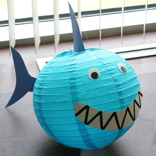 A large round paper lantern decorated to look like a shark