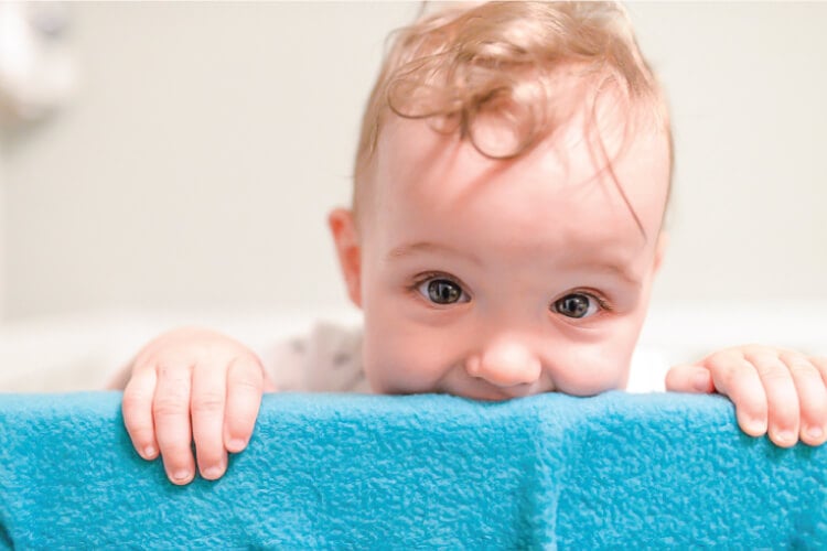 Baby chewing on the rails of his crib