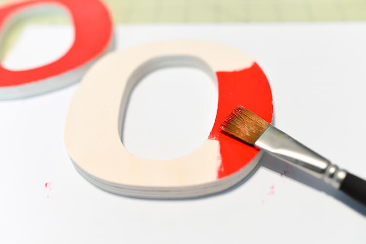 painting letters of DIY 4th of July tic tac toe lawn game