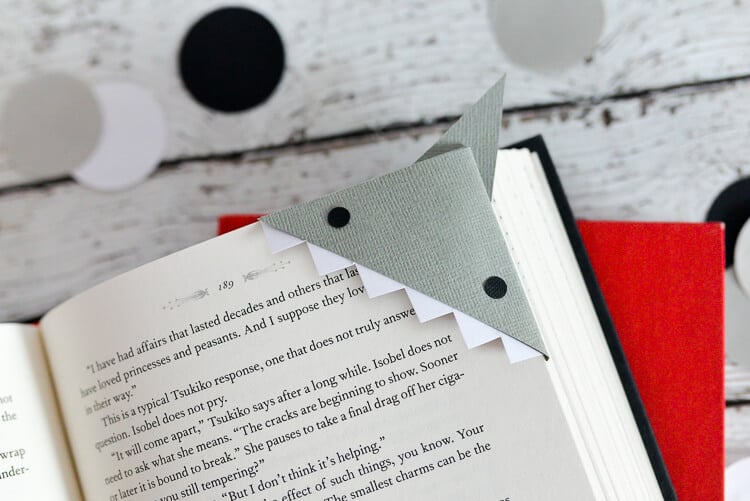 An open book with a shark bookmark in the upper right corner