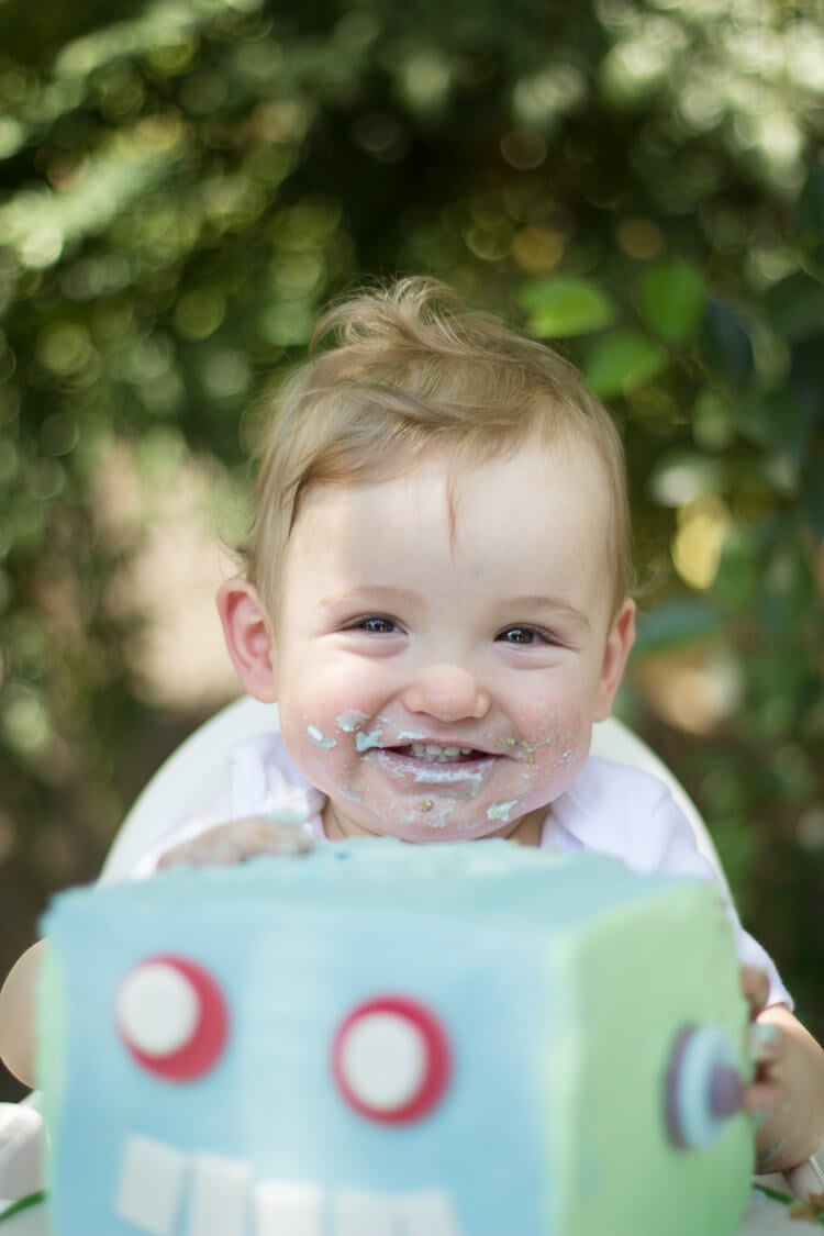 A little boy smiling with birthday cake all over his mouth