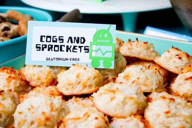 A close up of food with a sign that has an image of a robot on it and says, \"Cogs and Sprockets - Glutomium-Free\"