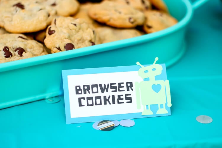 A plastic container of cookies and a sign with an image of a robot on it and says, \"Browser Cookies\"