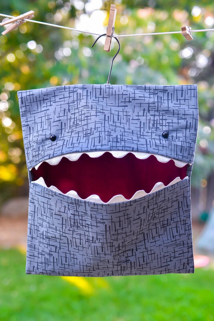 A shark clothespin bag hanging on a clothesline