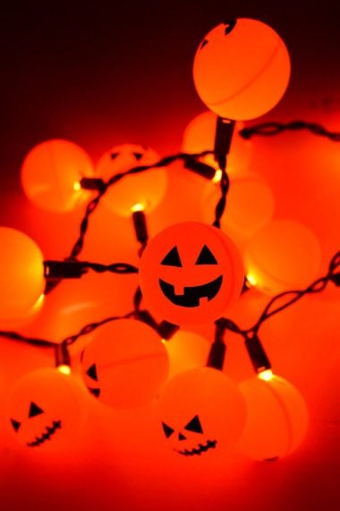 Orange ping pong balls plus fairy lights equal a fun Halloween Jack O' Lantern decoration! An easy project anyone can do.