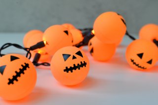 Orange ping pong balls plus fairy lights equal a fun Halloween Jack O' Lantern decoration! An easy project anyone can do.